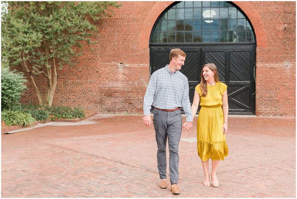 Engagement couple in yellow dress at historic tredegar ironworks doors in richmond virginia